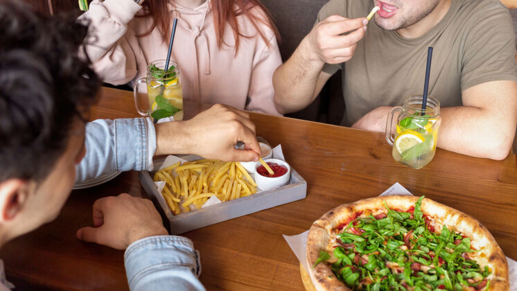 学生一群朋友在酒吧休息吃 喝 桌上的食物友谊咖啡馆生活方式休息