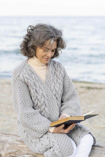 老年人海滩上的老太太在看书老年人户外老年人