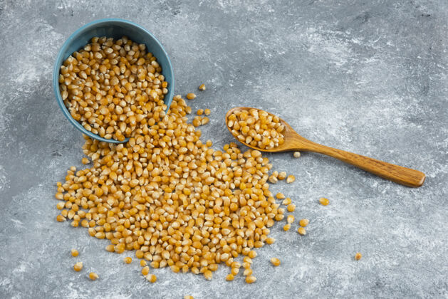 谷类把生玉米粒从碗里放在大理石表面上有机堆爆米花