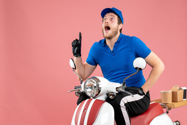 运动员正面图身着蓝色制服的男快递员骑着粉色快餐服务自行车送货工作彩色工作头盔颜色自行车