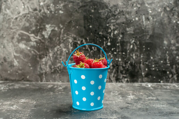 海正面图新鲜的红色覆盆子在灰色水果上的小篮子颜色蔓越莓野生照片浆果容器成虫桶