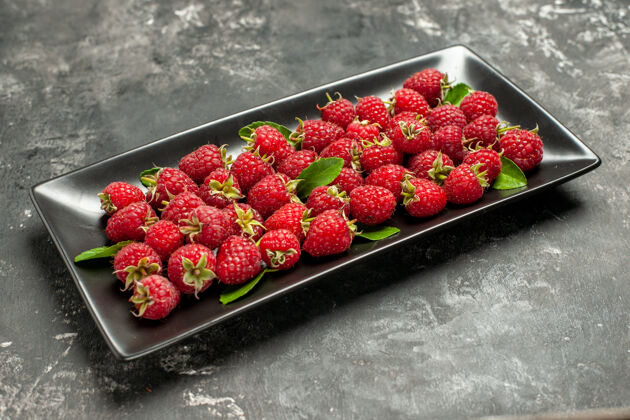 水果正面图新鲜的红色覆盆子在黑色的平底锅里 灰色的水果色的蔓越莓野生照片浆果草莓平底锅农产品