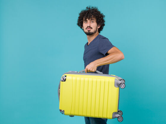 包度假的男人拿着蓝色的大黄色手提箱大男性假期