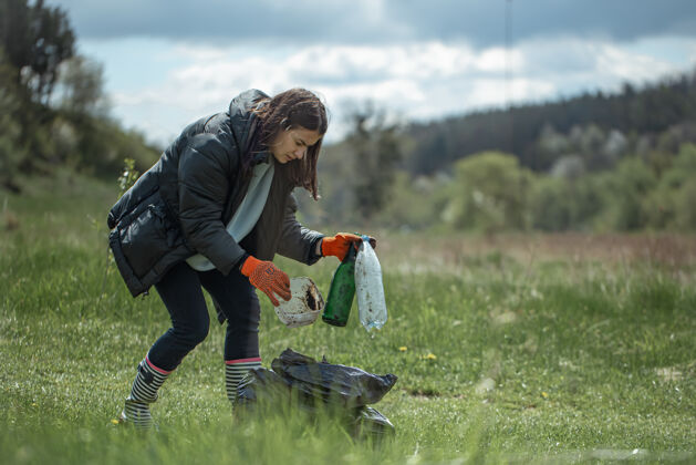女孩女孩志愿者在森林里收集垃圾 保护环境多样性草垃圾