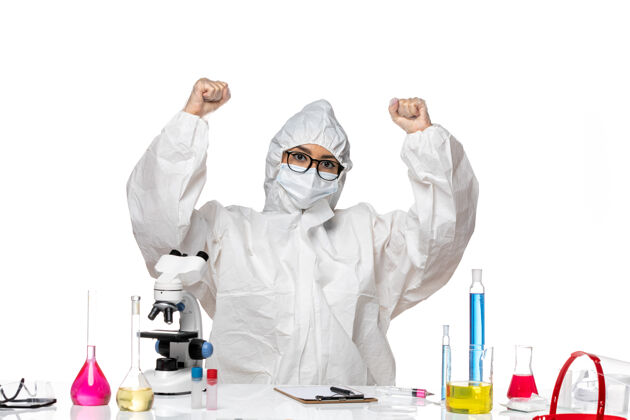 西装正面图身着特殊防护服的年轻女化学家坐在白色办公桌上欢呼雀跃的病毒实验室化学实验室外套药专业