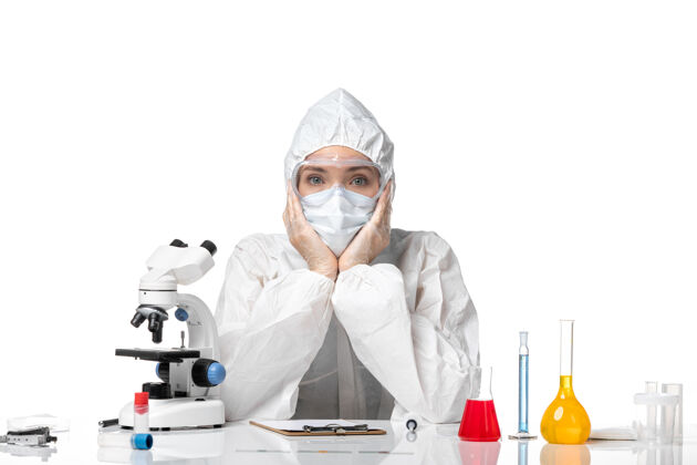 实验室外套正面图年轻女医生穿着防护服 戴着口罩 由于柯维德坐在白色背景上大流行 飞溅柯维德病毒医疗药品专业