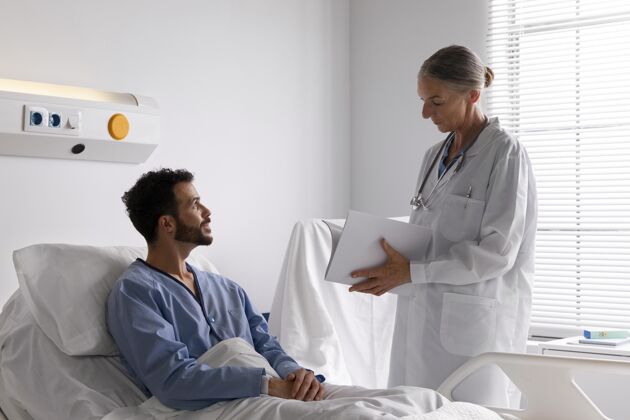 健病的男病人在床上和护士说话男人药品医疗