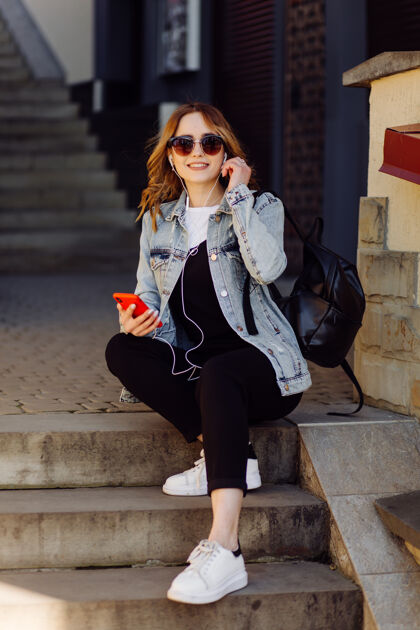 短信一个积极开朗的少女花时间在公园和使用手机的照片青少年短信手机