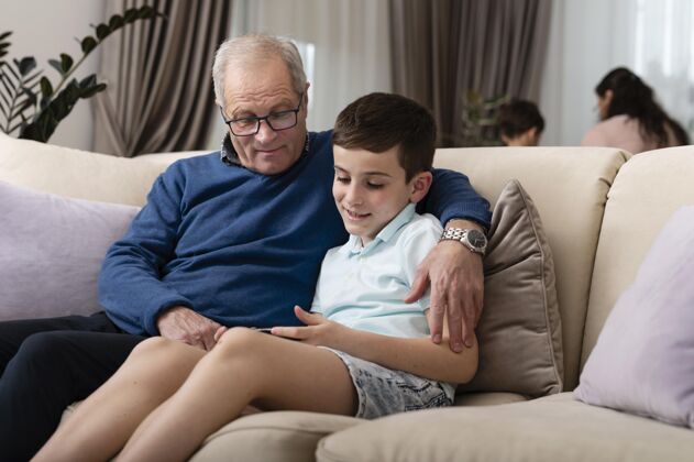 孩子孙子和爷爷在沙发上放松室内男孩祖父