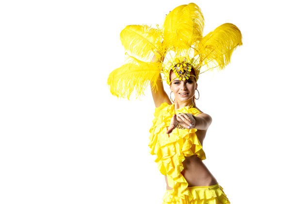 新表演身着嘉年华化装 黄色羽毛的美丽年轻女子在白色背景上翩翩起舞节日庆典 节日时间 舞蹈 聚会 快乐的概念复制空间女性神秘戏剧