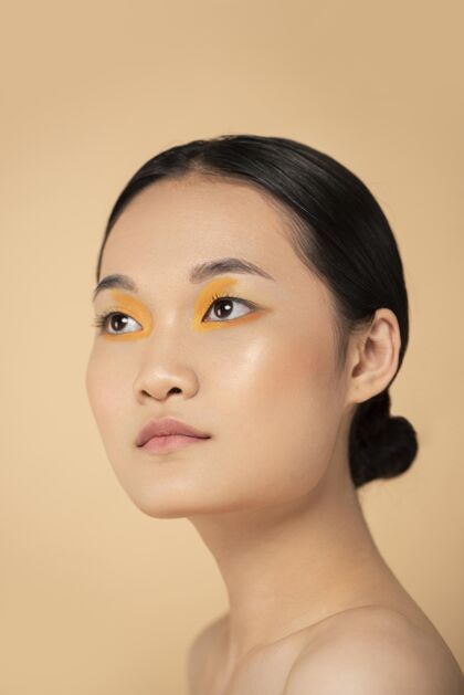 人美丽的亚洲女人戴着橙色眼影年轻亚洲人美丽