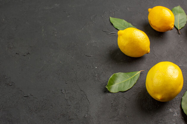 背景前视图新鲜酸柠檬衬在黑暗的背景可食用水果果汁新鲜