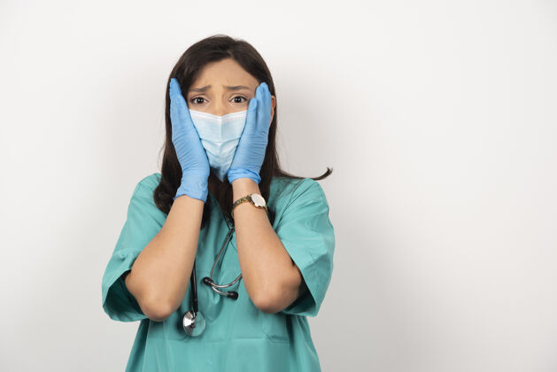 面罩医生戴着医用面罩和手套 脸上挂着白色的背景高质量的照片女性职业健康