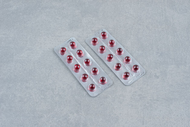药丸把椭圆形的红色药丸装在灰色的上面药物红色医学
