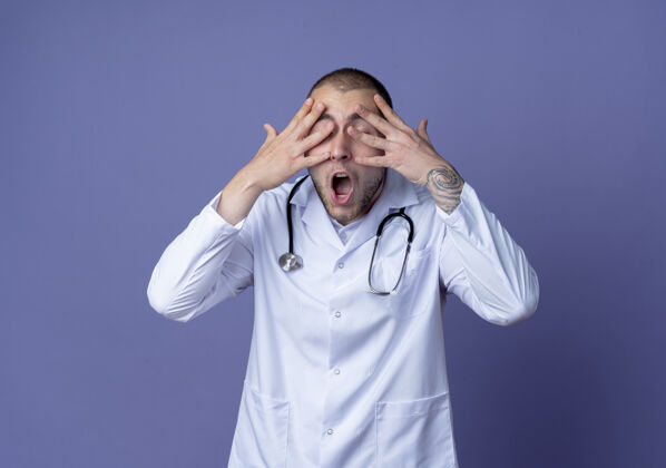 公民压力很大的年轻男医生 穿着医用长袍 手放在脸上 闭着眼睛 隔离在紫色的墙上穿着医学紫色