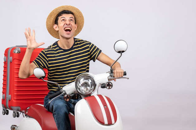 吸管一个戴着草帽的年轻人站在白色背景上 兴高采烈摩托车白色前面