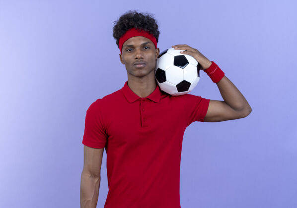 蓝色自信的年轻美国黑人运动男子戴着头带和手环 肩上拿着球腕带肩膀头带