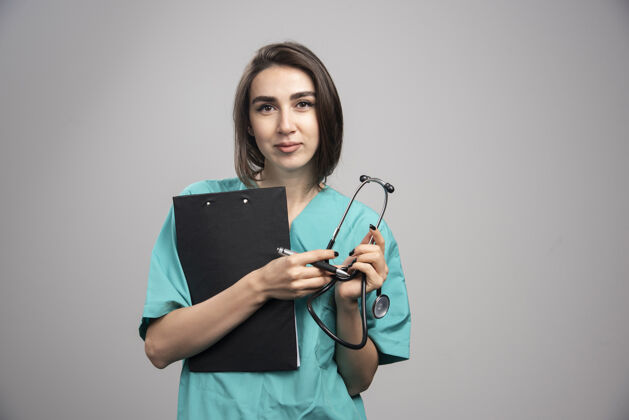 工作女医生用听诊器和剪贴板摆姿势高质量的照片医疗检查治疗