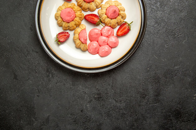 糖顶视图美味的小饼干与粉红色奶油内板在灰色的表面美味的小饼干健康茶