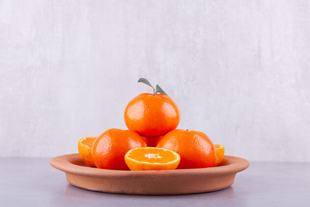 美味整个和切片的橘子叶放在石桌上美味美味国语