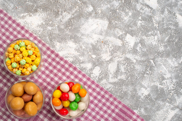 糖不同的甜糖果在白色表面眼镜内的俯视图盒子玻璃杯容器