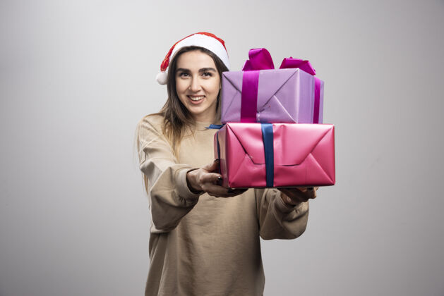 礼物送两盒圣诞礼物的年轻女子人抱着携带