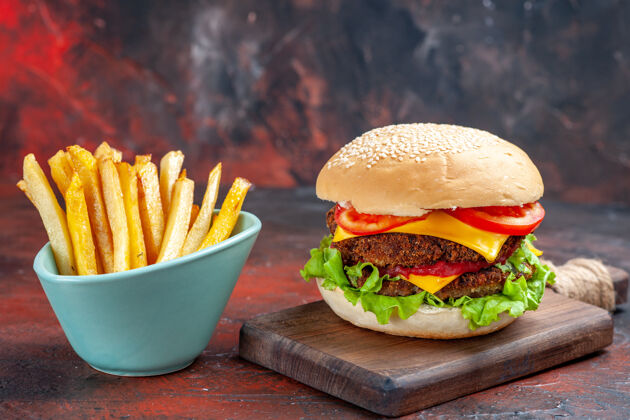 生菜前视图美味的肉汉堡与炸薯条在黑暗的背景西红柿薯条芝士汉堡
