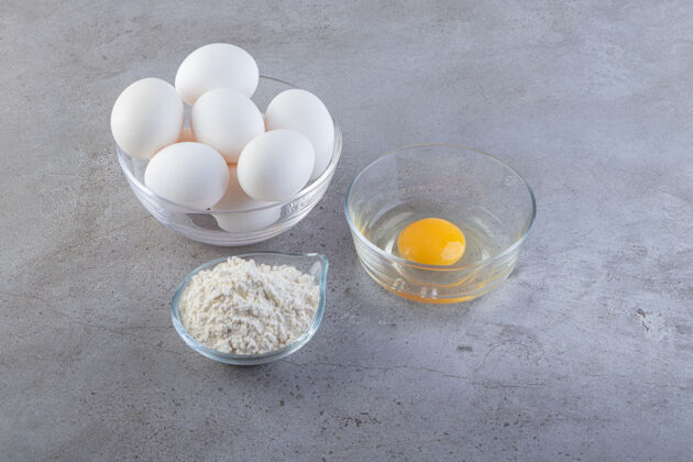 一餐一碗白鸡蛋和面粉放在石桌上蛋黄白早餐