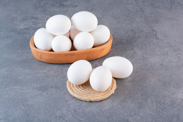 早餐石桌上放满生鸡蛋的泥碗团体家禽烹饪
