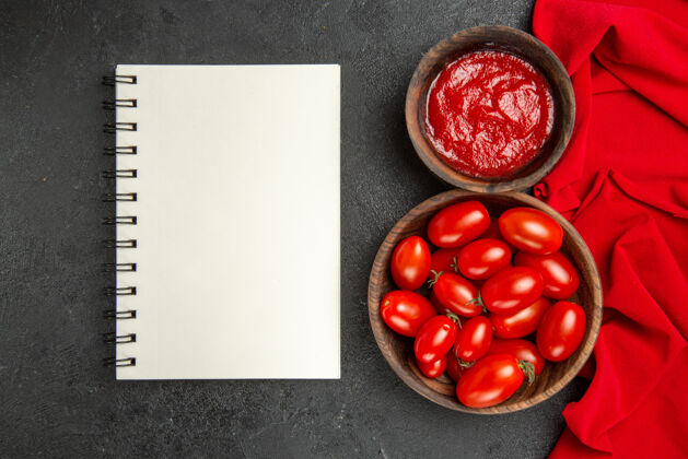 健康顶视图碗樱桃番茄和番茄酱红毛巾一个笔记本在黑暗的背景配料有机水果