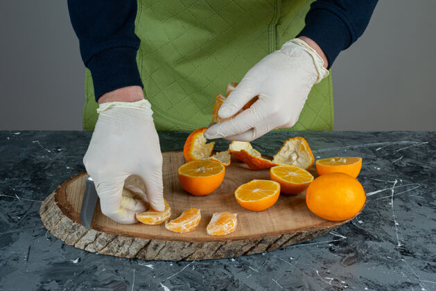 各种男性手戴手套 手拿橘子片放在大理石桌上男水果橘子