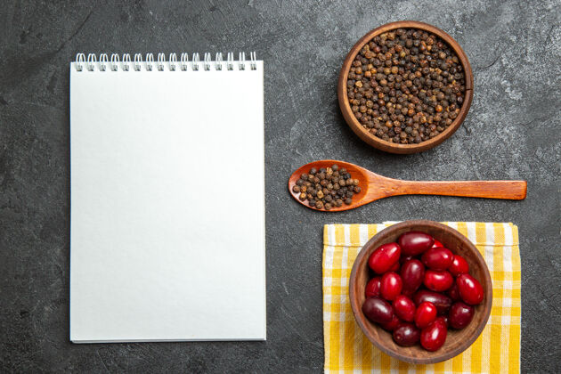 健康新鲜的红色山茱萸和胡椒粉在灰色的表面俯视图食物甜点浆果