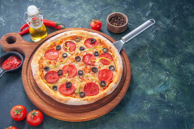 面团美味的自制比萨饼在木板上油瓶西红柿胡椒在黑暗的表面板一餐自制比萨饼