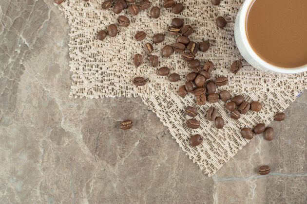 咖啡咖啡杯和咖啡豆在大理石表面与粗麻布杯子餐