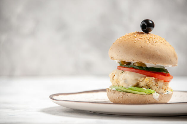 生菜自制美味三明治的俯视图 在一个盘子的左侧 白色的污渍表面零食食物左