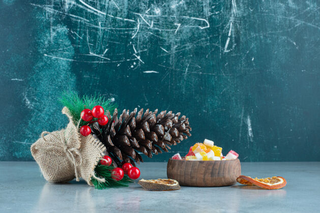 干的一个圣诞松果和一个木制的糖果碗好吃的水果食物