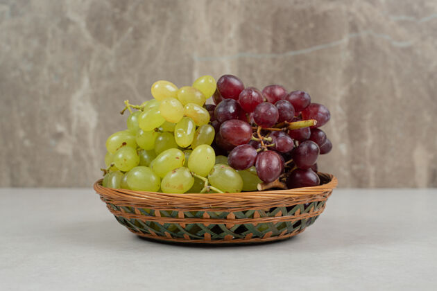 串新鲜的红绿葡萄放在木篮里有机新鲜天然