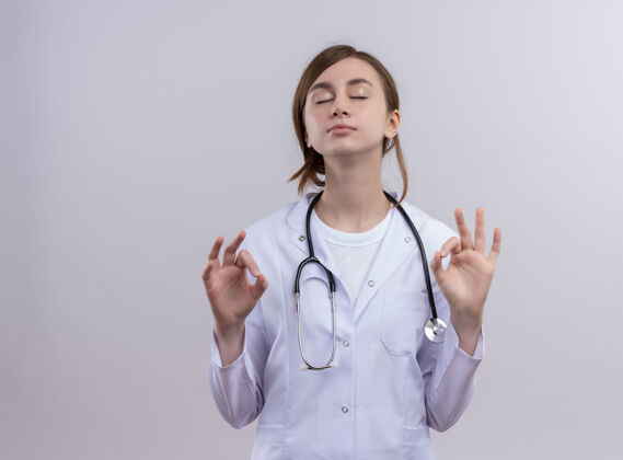 可以和平年轻的女医生穿着医用长袍和听诊器做ok标志闭上眼睛和复印空间和平听诊器医生
