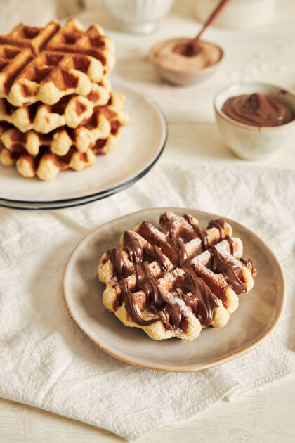 甜点在白色桌子上垂直拍摄美味的华夫饼和巧克力酱早餐巧克力粉