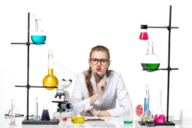 实验室前视图穿着医疗服的女化学家在白色背景上写笔记化学大流行健康covid化学医学套装