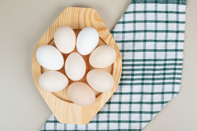 未煮熟的几个新鲜的鸡蛋放在木盘上家禽生的切碎的