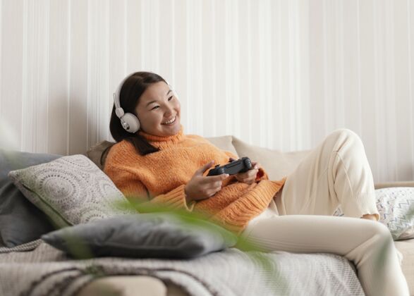 乐趣中枪女孩在沙发上玩游戏中镜头水平视频游戏