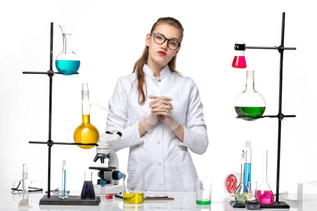 化学前视图：身着医疗服的女化学家站在白色背景上 拿着溶液化学病毒大流行病毒covid-医学前面立场