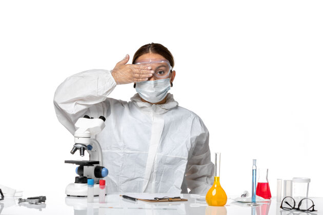 实验室外套前视图女医生穿着特制的西服 戴着口罩 坐在白色背景上解一种冠状病毒大流行医院视图病毒