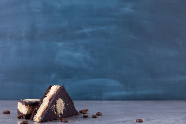 美食三角形的黑巧克力蛋糕片和咖啡豆面包房甜点可可