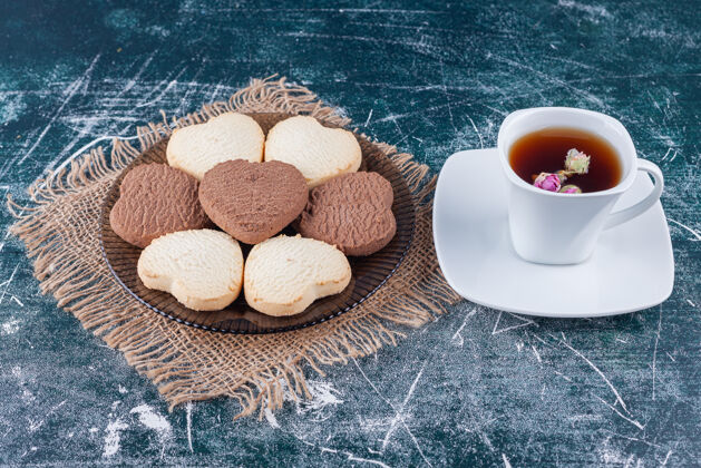 玻璃香喷喷的新鲜心形饼干和一杯木片凉茶美味烘焙巧克力