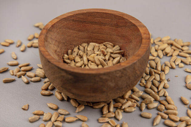 健康顶视图烤去壳葵花籽在一个木碗与去壳籽隔离壳种子粮食