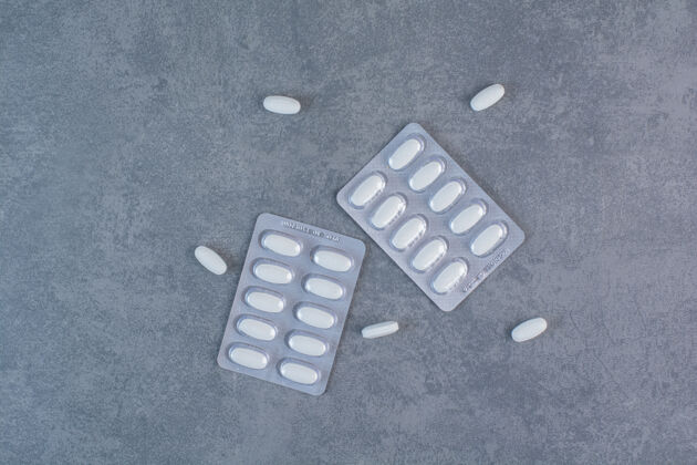 药品大理石表面有两包白色药丸药品药房片剂
