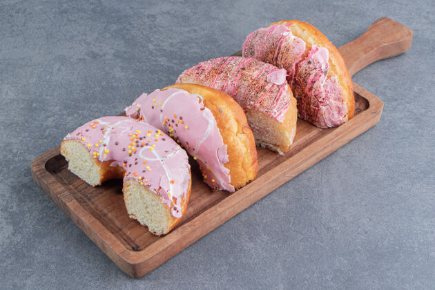 食物切碎的蛋糕和粉红色的糖霜放在木板上霜糖不健康