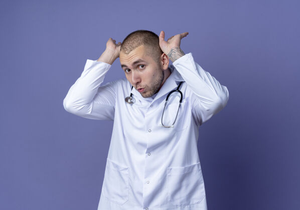 医生印象深刻的年轻男医生穿着医用长袍和听诊器把手放在靠近头部的紫色隔离带上印象近紫色